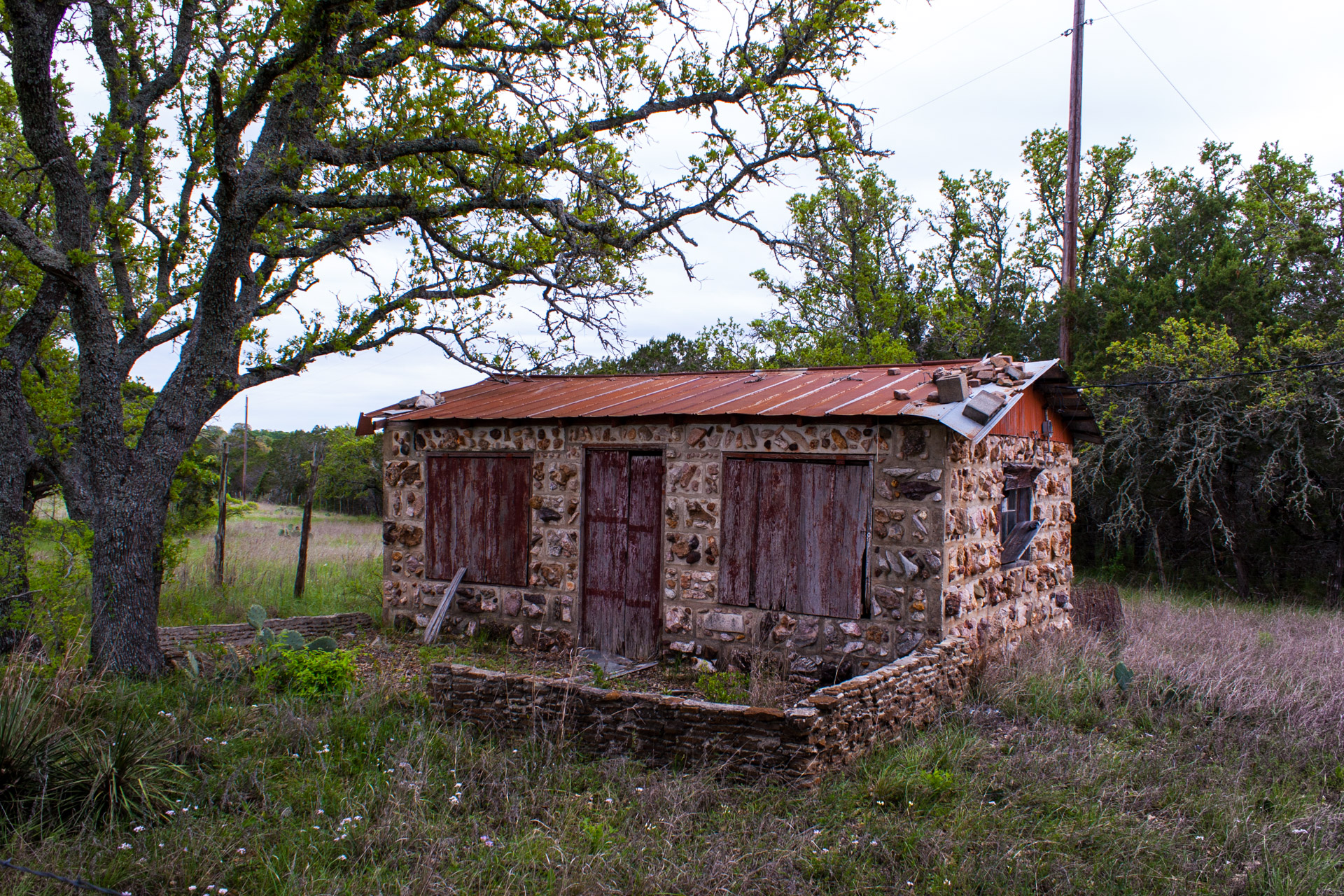Burnet, Texas - A Red Stone Cottage With Bluebonnets (angle right)