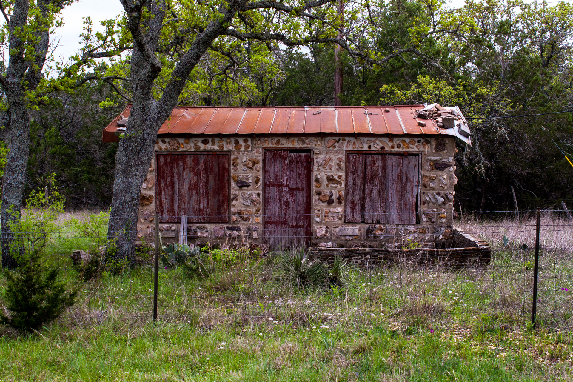 Burnet, Texas - A Red Stone Cottage With Bluebonnets (front mid)