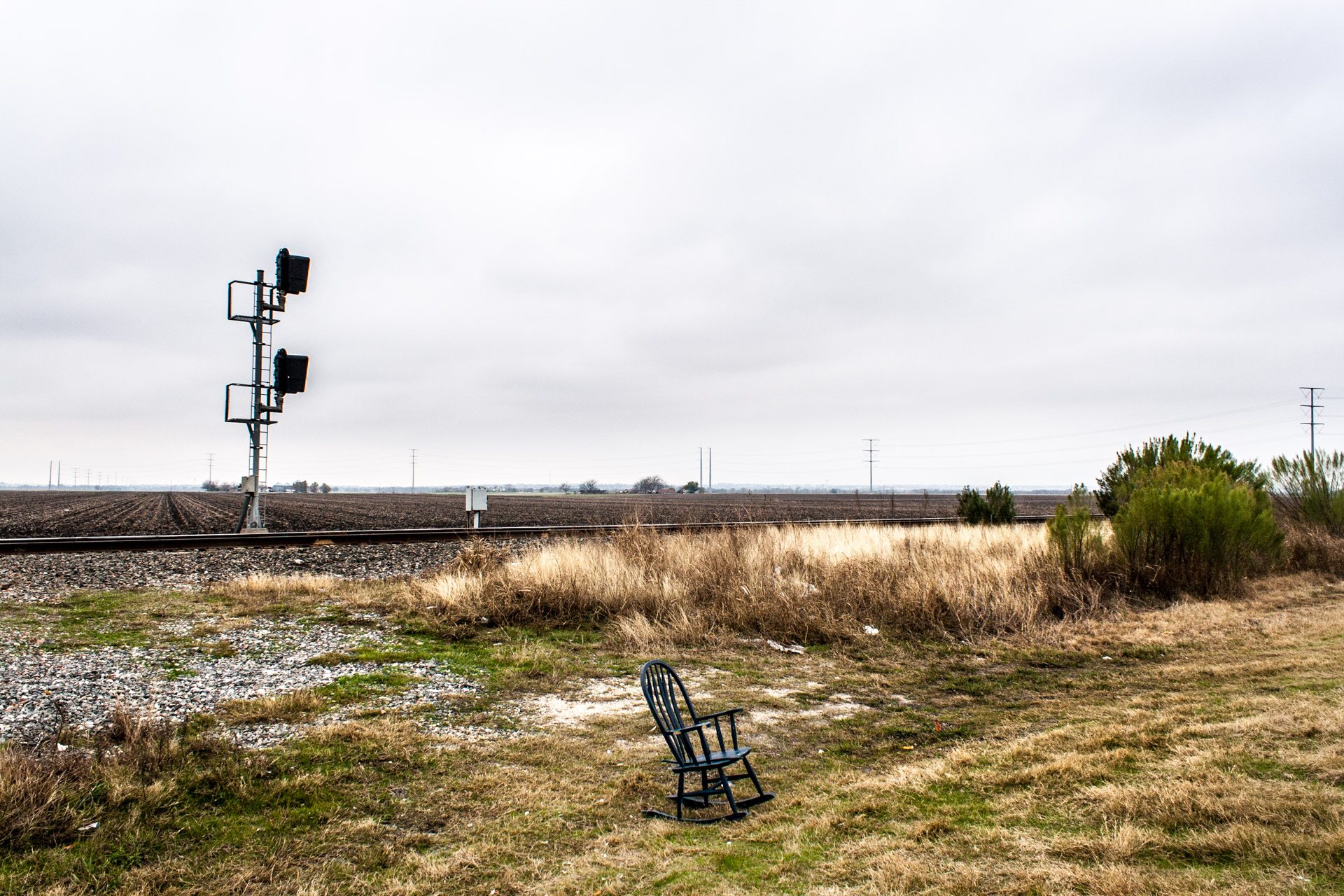 Hutto, Texas - A Rocking Chair In Front Of Railroad Tracks